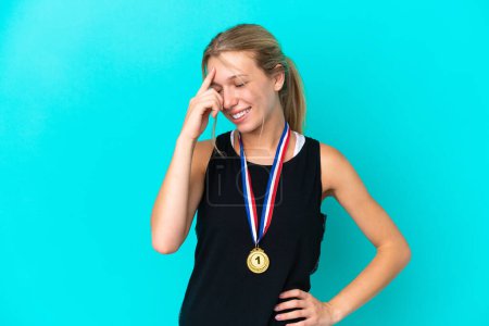 Photo for Young caucasian woman with medals isolated on blue background laughing - Royalty Free Image