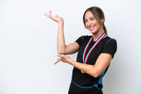 Photo for Young caucasian woman with medals isolated on white background extending hands to the side for inviting to come - Royalty Free Image