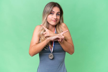 Photo for Young pretty sport Uruguayan woman with medals over isolated background pointing to the laterals having doubts - Royalty Free Image
