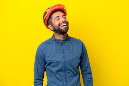 Photo for Young cyclist Brazilian man isolated on yellow background laughing - Royalty Free Image