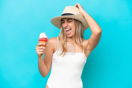 Photo for Young caucasian woman in swimsuit with a cornet ice cream isolated on blue background has realized something and intending the solution - Royalty Free Image