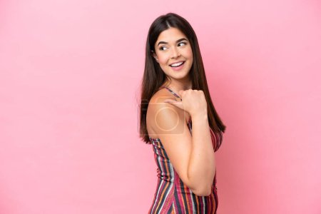 Photo for Young Brazilian woman isolated on pink background pointing to the side to present a product - Royalty Free Image