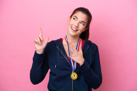 Photo for Young Brazilian sport woman with medals isolated on pink background pointing with the index finger a great idea - Royalty Free Image