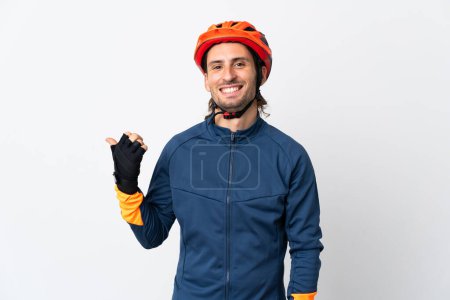 Photo for Young cyclist man isolated on white background pointing to the side to present a product - Royalty Free Image