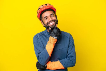 Photo for Young cyclist Brazilian man isolated on yellow background happy and smiling - Royalty Free Image