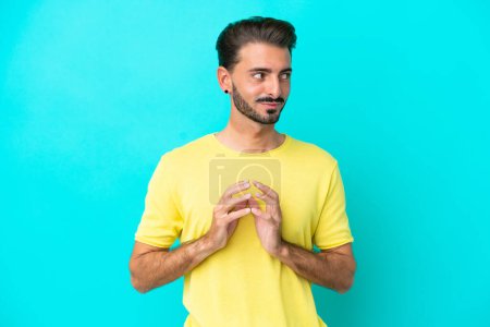 Photo for Young caucasian man isolated on blue background scheming something - Royalty Free Image