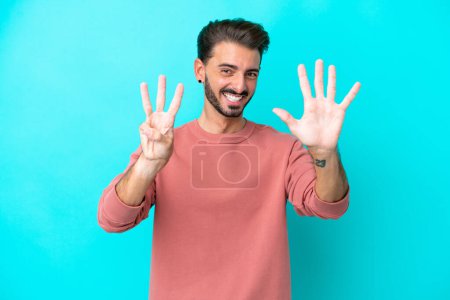 Photo for Young caucasian man isolated on blue background counting eight with fingers - Royalty Free Image