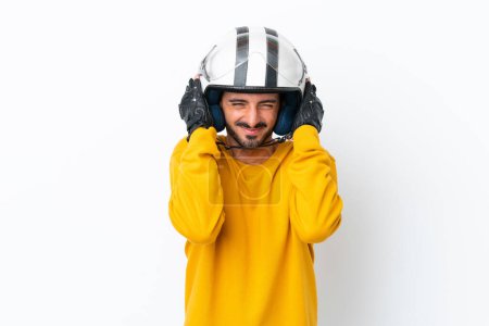 Téléchargez les photos : Jeune homme caucasien avec un casque de moto isolé sur fond blanc frustré et couvrant les oreilles - en image libre de droit