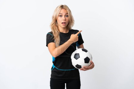Photo for Young Russian woman playing football isolated on white background surprised and pointing side - Royalty Free Image