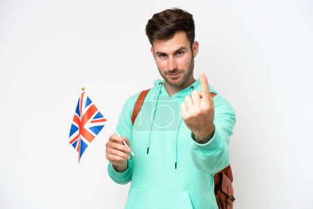 Téléchargez les photos : Jeune étudiant caucasien homme tenant un drapeau du Royaume-Uni isolé sur fond blanc faisant geste à venir - en image libre de droit