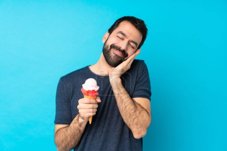 Photo for Young man with a cornet ice cream over isolated blue background making sleep gesture in dorable expression - Royalty Free Image