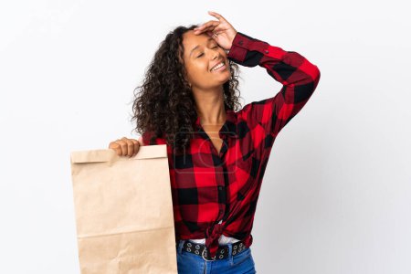 Photo for Teenager girl holding a grocery shopping bag to takeaway isolated on white background smiling a lot - Royalty Free Image