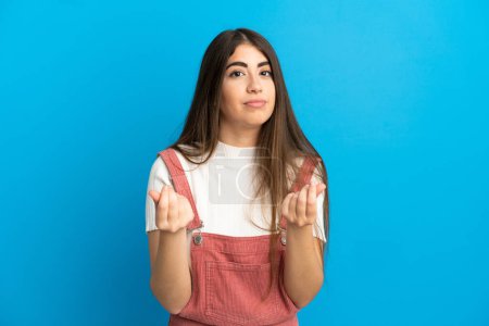 Photo for Young caucasian woman isolated on blue background making money gesture but is ruined - Royalty Free Image