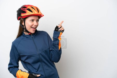 Téléchargez les photos : Jeune cycliste lituanienne isolée sur fond blanc pointant du doigt sur le côté et présentant un produit - en image libre de droit