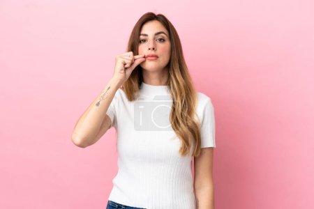Photo for Caucasian woman isolated on pink background showing a sign of silence gesture - Royalty Free Image