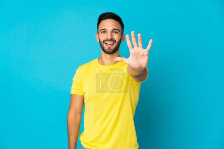 Photo for Young caucasian man isolated on blue background counting five with fingers - Royalty Free Image