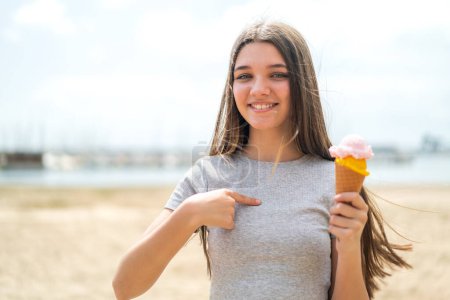 Foto de Chica adolescente con un helado de corneta al aire libre con expresión facial sorpresa - Imagen libre de derechos