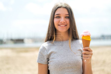 Foto de Chica adolescente con un helado de corneta al aire libre sonriendo mucho - Imagen libre de derechos