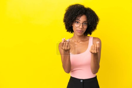 Téléchargez les photos : Jeune femme afro-américaine isolée sur fond jaune faisant geste d'argent mais est ruinée - en image libre de droit