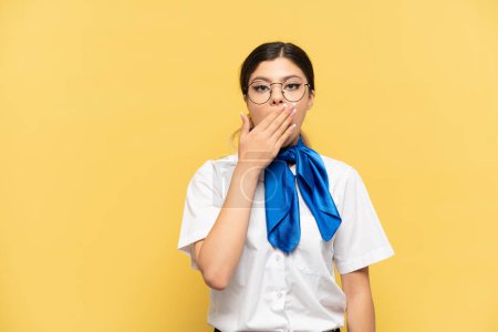 Photo for Airplane stewardess isolated on yellow background happy and smiling covering mouth with hand - Royalty Free Image