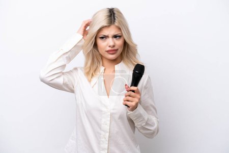 Photo for Young singer woman picking up a microphone isolated on white background having doubts - Royalty Free Image