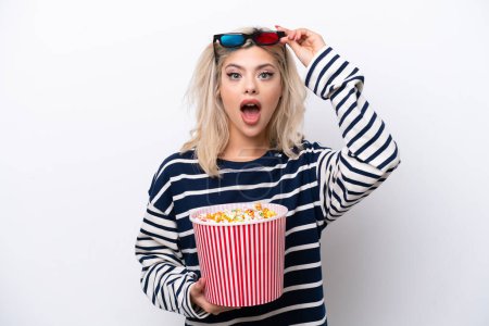 Téléchargez les photos : Jeune femme russe isolée sur fond blanc surprise avec des lunettes 3D et tenant un grand seau de popcorns - en image libre de droit