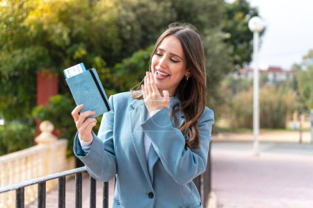 Photo for Young pretty woman holding a passport at outdoors with surprise and shocked facial expression - Royalty Free Image