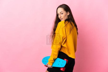 Photo for Young hispanic woman over isolated pink background with a skate - Royalty Free Image