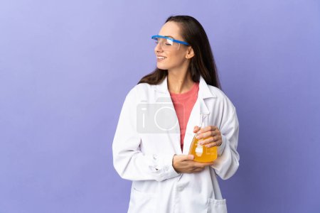 Foto de Mujer científica joven sobre fondo aislado mirando hacia un lado y sonriendo - Imagen libre de derechos