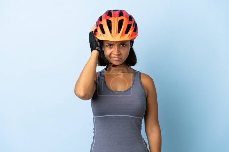 Téléchargez les photos : Jeune cycliste femme isolée sur fond bleu avec une expression de frustration et de ne pas comprendre - en image libre de droit