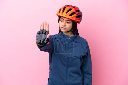 Téléchargez les photos : Adolescente cycliste fille isolé sur fond rose faire geste d'arrêt et déçu - en image libre de droit