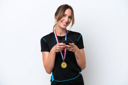 Photo for Young caucasian woman with medals isolated on white background sending a message with the mobile - Royalty Free Image