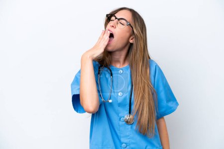 Photo for Young surgeon doctor woman isolated on blue background yawning and covering wide open mouth with hand - Royalty Free Image