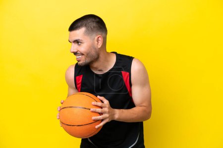 Téléchargez les photos : Jeune joueur de basket-ball homme sur fond blanc isolé rire - en image libre de droit