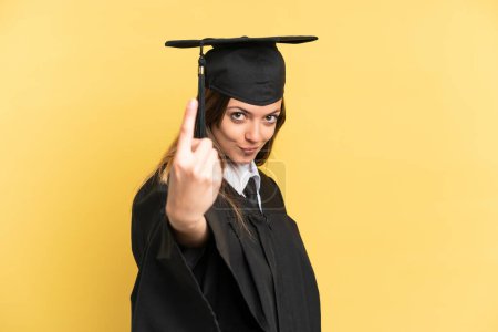 Photo for Young university graduate isolated on yellow background doing coming gesture - Royalty Free Image