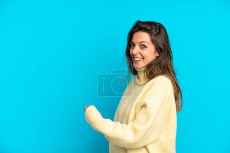 Photo for Young caucasian woman isolated on blue background pointing back - Royalty Free Image