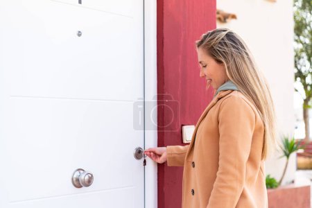 Foto de Joven mujer rubia sosteniendo las llaves de casa al aire libre - Imagen libre de derechos