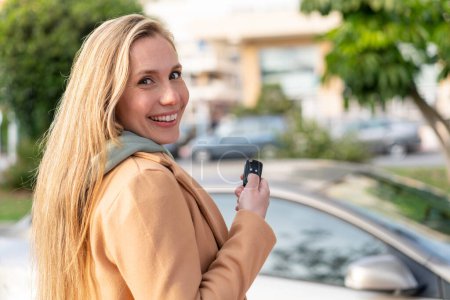 Téléchargez les photos : Jeune femme blonde tenant des clés de voiture à l'extérieur - en image libre de droit