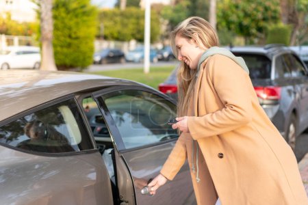 Téléchargez les photos : Jeune femme blonde tenant des clés de voiture à l'extérieur - en image libre de droit