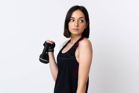 Téléchargez les photos : Jeune femme caucasienne isolée sur fond blanc faisant haltérophilie avec kettlebell - en image libre de droit
