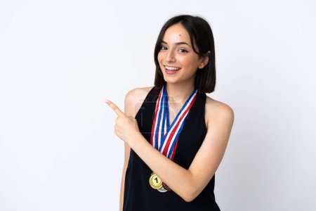 Photo for Young woman with medals isolated on white background pointing to the side to present a product - Royalty Free Image