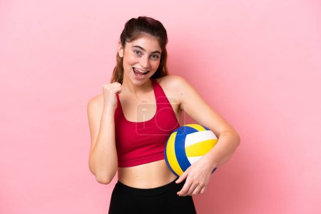Téléchargez les photos : Jeune femme caucasienne jouant au volley isolé sur fond rose célébrant une victoire en position gagnante - en image libre de droit