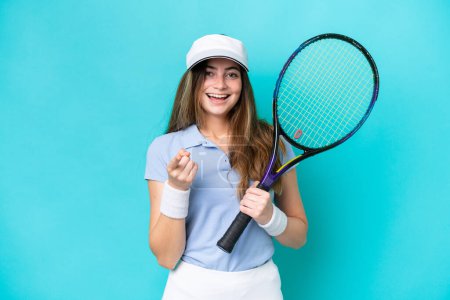 Téléchargez les photos : Jeune joueuse de tennis isolée sur fond bleu surprise et pointant devant - en image libre de droit