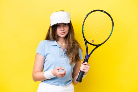 Foto de Joven mujer caucásica aislada sobre fondo amarillo jugando tenis - Imagen libre de derechos