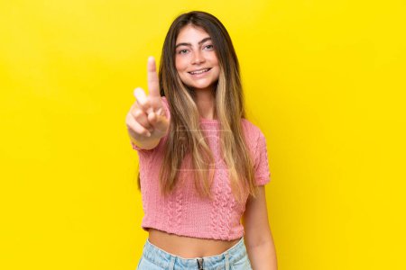 Foto de Mujer joven caucásica aislada sobre fondo amarillo mostrando y levantando un dedo - Imagen libre de derechos