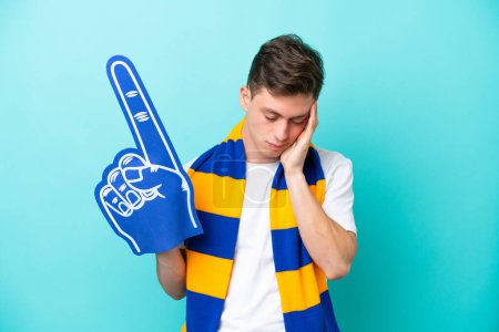 Photo for Young sports fan man isolated on blue background with headache - Royalty Free Image
