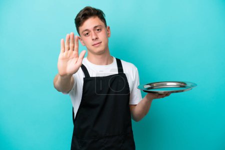 Photo for Young waitress with tray isolated on blue background making stop gesture - Royalty Free Image