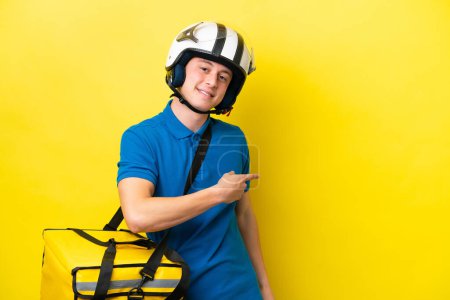 Photo for Young Brazilian man with thermal backpack isolated on yellow background pointing finger to the side - Royalty Free Image