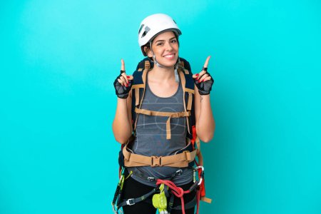 Téléchargez les photos : Jeune alpiniste italienne isolée sur fond bleu pointant vers le haut d'une excellente idée - en image libre de droit