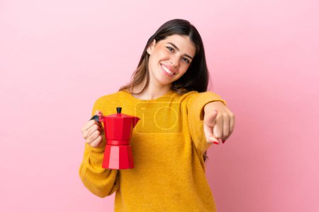 Photo for Young Italian woman holding a coffee maker isolated on pink background pointing front with happy expression - Royalty Free Image